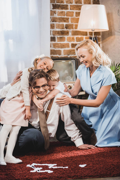 ευτυχισμένη οικογένεια vintage αγκάλιασμα παίζοντας ντόμινο στο σπίτι  - Φωτογραφία, εικόνα
