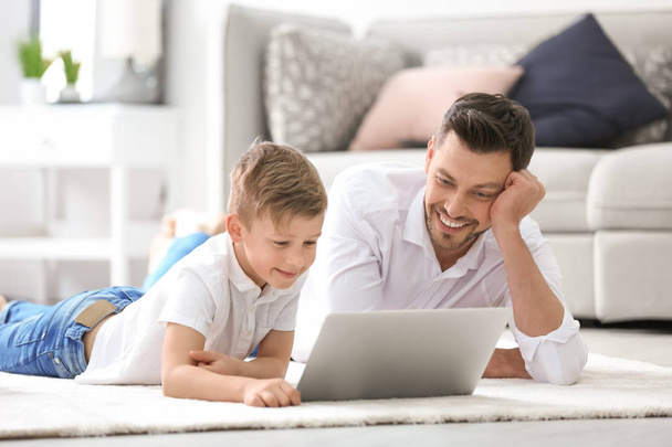 Little boy and his dad using laptop at home - Fotografie, Obrázek