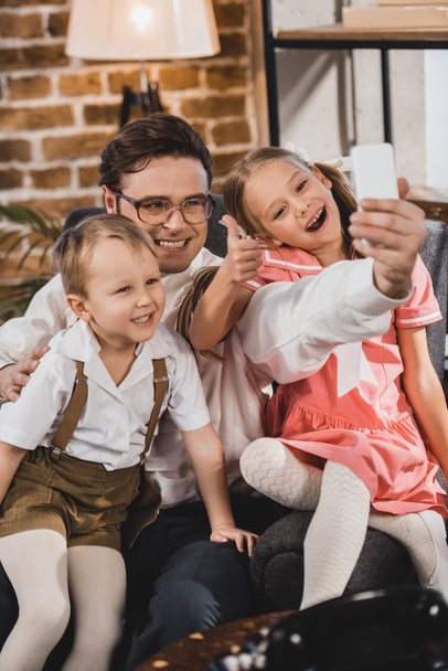 Happy roku 1950 styl rodiny pořizování selfie s smartphone doma  - Fotografie, Obrázek