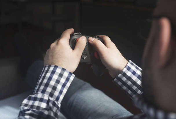 молодой человек держит джойстик и играет в видеоигры, расслабляя хав
 - Фото, изображение