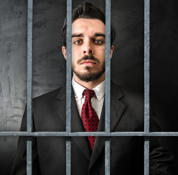 fiatal üzletember börtönben sötét háttér - Fotó, kép