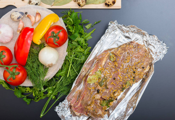 High angle view of marinated meat on foil near vegetables on a g - Fotografie, Obrázek