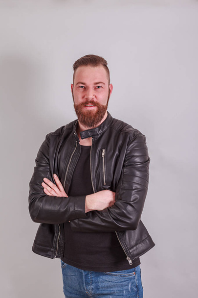 Portrait of a sympathetic man with leather jacket and folded arms - Photo, Image