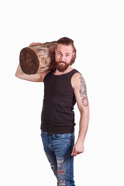 Homem usando tronco de árvore em seu ombro
 - Foto, Imagem