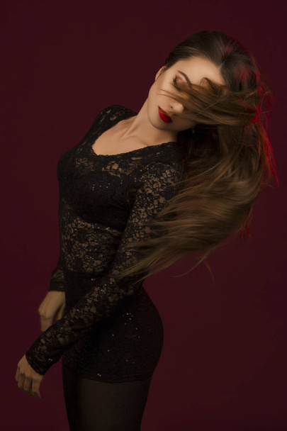 Młoda piękna kobieta tańczy w czarnej sukni z zamkniętymi oczami i - Zdjęcie, obraz