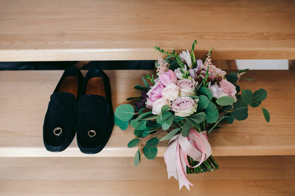 wedding rings on groom shoes and wedding flowers - 写真・画像