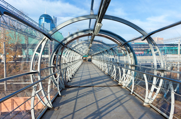 Puente de acero y vidrio para peatones que cruzan el ferrocarril
 - Foto, imagen