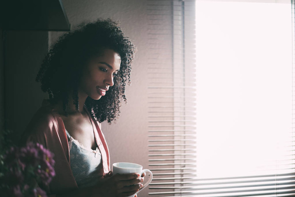 bonita mujer negra sentada en la ventana con una taza de café
 - Foto, imagen