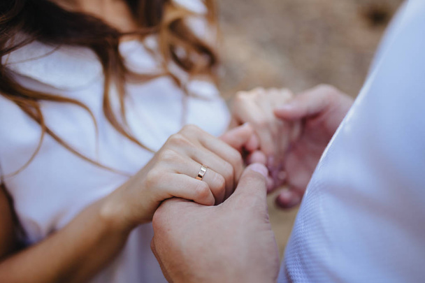 Οι λάτρεις κρατώντας τα χέρια με χρυσά γαμήλια δαχτυλίδια. Νύφη και το γαμπρό. - Φωτογραφία, εικόνα