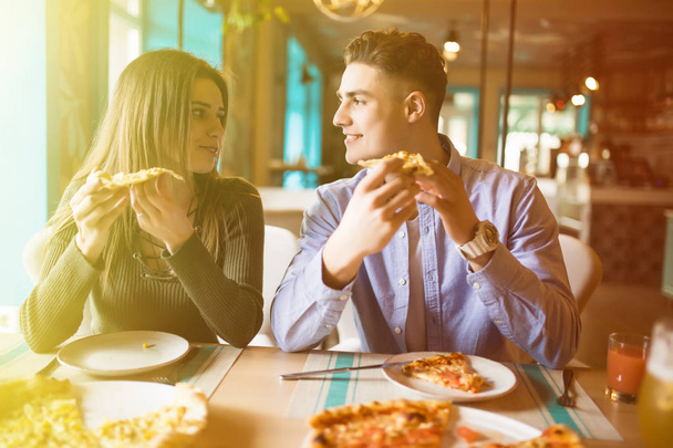 若いカップルのピザを楽しんで、一緒に楽しんで。消費者、食品、ライフ スタイルのコンセプト - 写真・画像