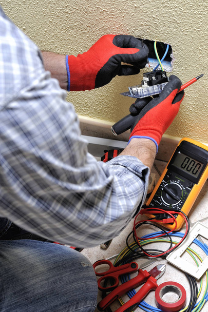 Technicien électricien au travail avec équipement de sécurité sur un système électrique résidentiel
 - Photo, image