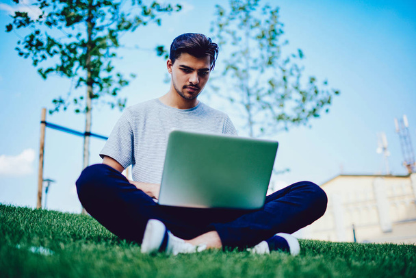 Концентрований молодий студент чоловічої статі, який проводить дослідження онлайн на ноутбуці комп'ютера
. - Фото, зображення