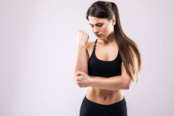 Sporty woman having pain in hers elbow, hands ache isolated on white background - Foto, immagini