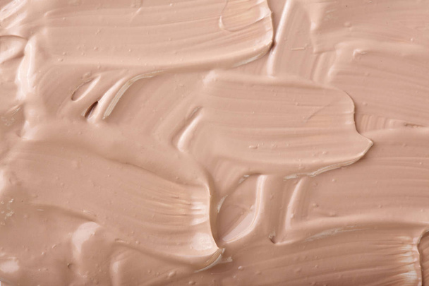 Beige liquid foundation makeup as a background. Top view. Flat lay pattern - Foto, afbeelding