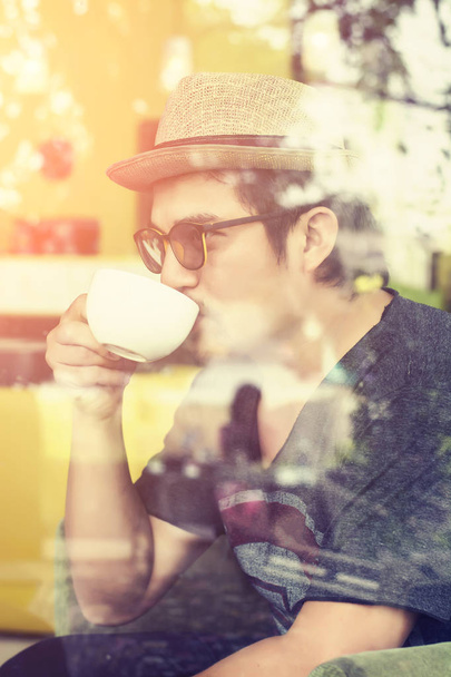 Młody człowiek pije kawę do kawiarni z sunrise - Zdjęcie, obraz