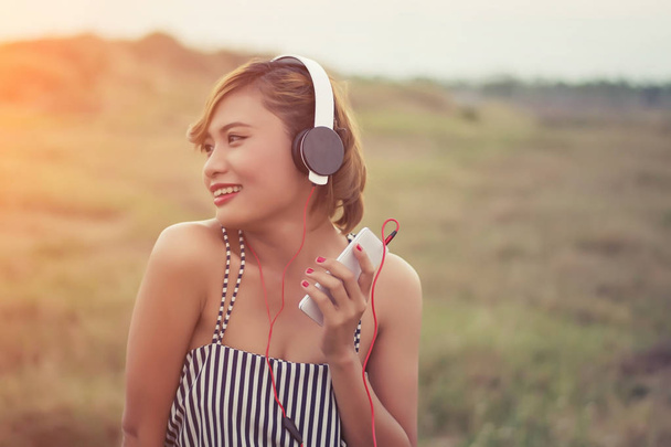 hermosa mujer sexy con vestido azul de pie escuchando música en
 - Foto, imagen