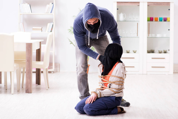 Bewaffneter Mann überfällt junge Frau zu Hause - Foto, Bild