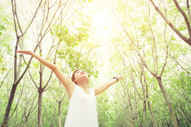Young beautiful woman raised arms enjoying the fresh air in gree - Photo, Image