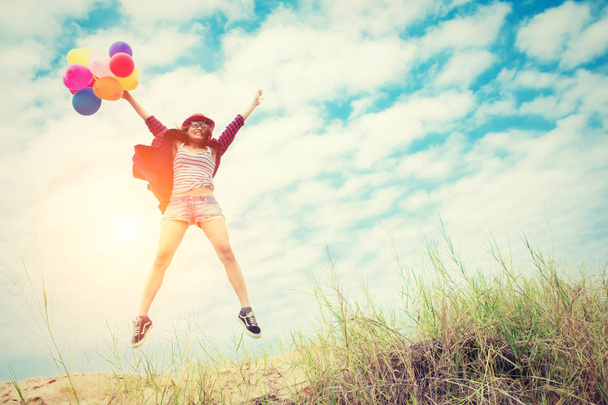 Красива дівчина стрибає з повітряними кулями на пляжі
 - Фото, зображення