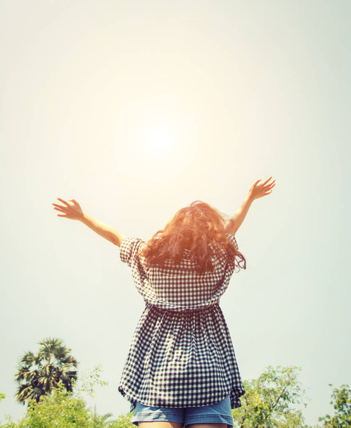Mujer joven levanta las manos hacia el cielo con el amanecer tan fresco
. - Foto, imagen