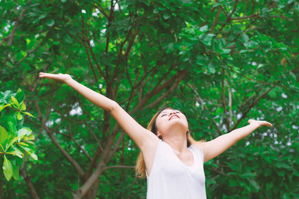 Eine glückliche Frau, die in der Luft steht, breitet ihre Arme aus. Frische Luft genießen - Foto, Bild