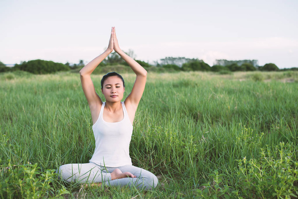 nő fiatal jóga meditáció ülni a rétek. - Fotó, kép