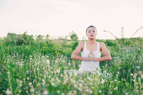 здоровой и красивой молодой женщиной йоги, сидящей с объединенной рукой
 - Фото, изображение