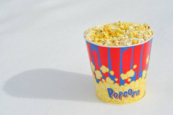 popcorn bucket in winter standing on snow - Foto, Imagen