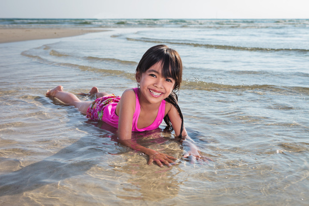 小さな女の子がビーチで遊んで - 写真・画像