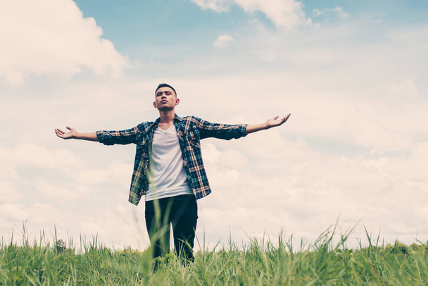 Απολαύστε ελευθερία εφηβική νεαρός τεντώνοντας τα χέρια του στον ουρανό - Φωτογραφία, εικόνα