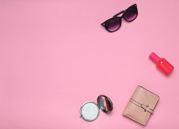 Copia lo spazio del layout di accessori moda femminile su uno sfondo rosa. Specchio, occhiali da sole, borsetta, bottiglia di profumo. Vista dall'alto
. - Foto, immagini