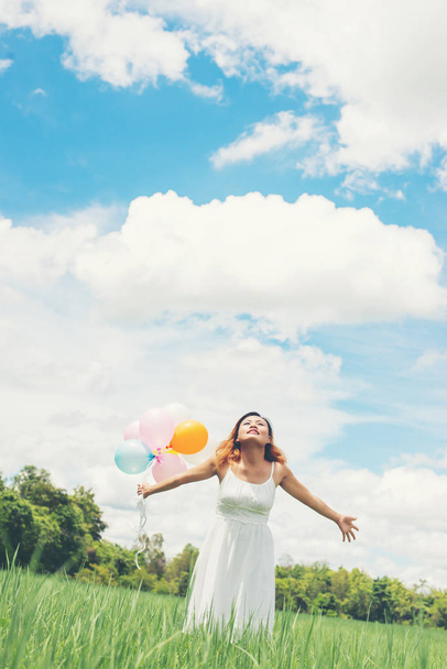 Boldog fiatal gyönyörű nő a fű mező enj léggömbök - Fotó, kép