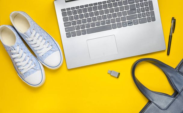 Digital technology and fashionable women's accessories on a yellow background: laptop, usb flash drive, bag, wallet, sneakers, bag. Top view. Flat lay. - Fotoğraf, Görsel