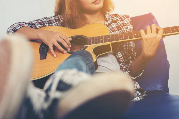 Молода хіпстерка грає на гітарі
. - Фото, зображення