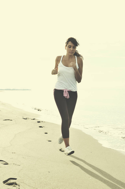young healthy woman jogging and running at beach at early morning  - Foto, Imagem