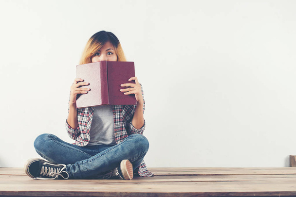 Giovane hipster donna ha preso il libro dalla sua faccia con timidezza, whe
 - Foto, immagini