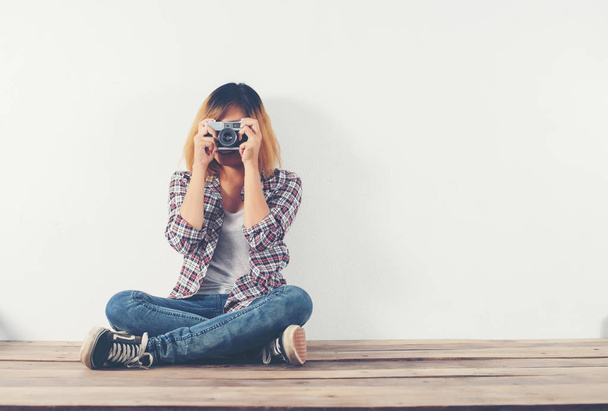 Молода жінка-гіпстер фотограф фотографує і дивиться на камеру
 - Фото, зображення