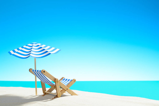 Una chaise longue bajo un paraguas en la playa de arena junto al mar y el cielo con espacio para copiar
 - Foto, imagen