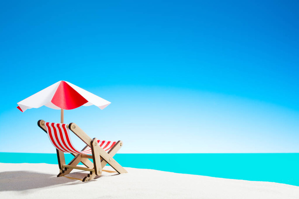 Une chaise longue sous un parapluie sur la plage de sable fin au bord de la mer et le ciel avec espace de copie
 - Photo, image