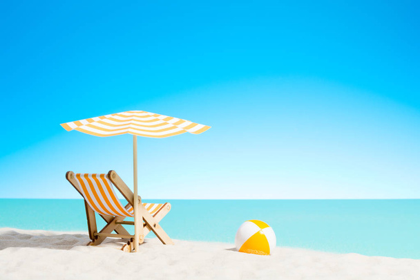 Lounge chair with parasol and beach ball on the coast - Photo, Image