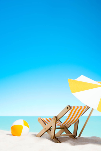 Leżak z parasolem i piłka plażowa na wybrzeżu - Zdjęcie, obraz