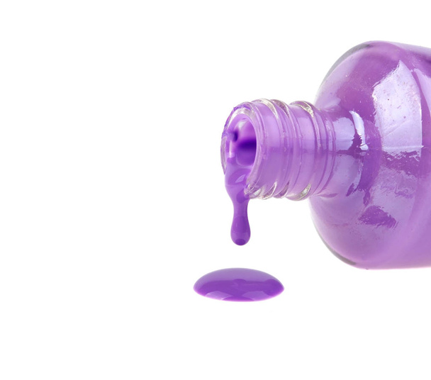 Flacon de vernis à ongles violet avec éclaboussure sur fond blanc
 - Photo, image