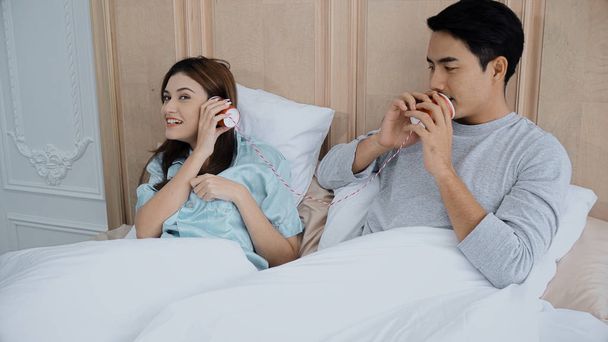Young married couple playing with can phone to talking together - 写真・画像
