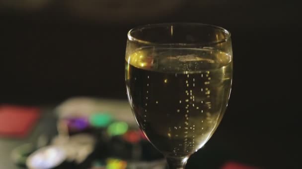 glass of champagne on the game table - Filmati, video