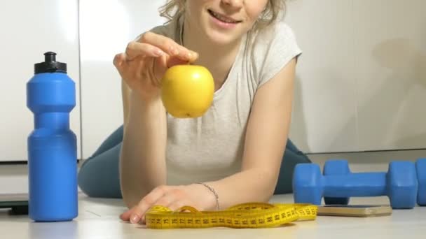 Aktywne sportowe sportowy kobieta ręcznikiem w sport strój jedzenia jabłko po treningu - Materiał filmowy, wideo