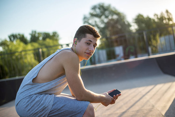 A young guy listens to music before training - Foto, Imagem