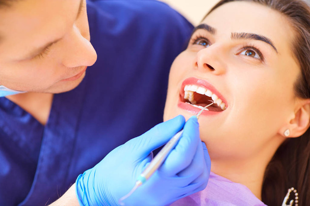 The dentist man are treating teeth to  client in dental office - Valokuva, kuva