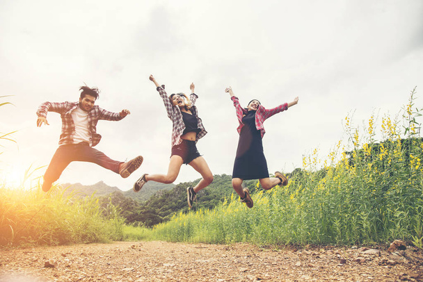 Group of Hipster Teenagers Jumping at the flower field. - Фото, изображение
