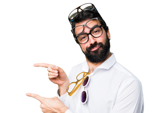 Handsome man with glasses pointing to the lateral - Photo, Image