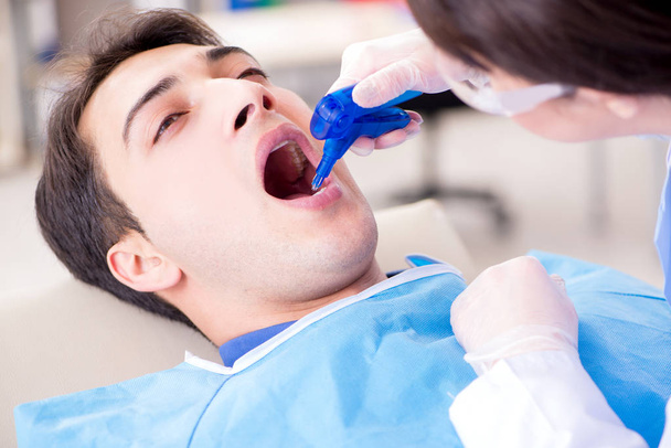 Dentiste visiteur patient pour un contrôle et un remplissage réguliers - Photo, image